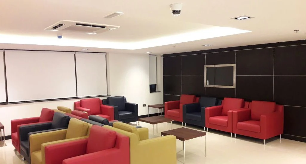 A well-appointed waiting area in Emirates Office, Tanzania, showcasing comfortable chairs and a television.